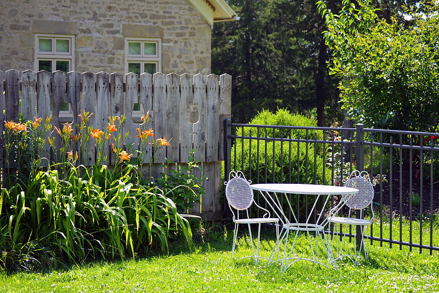 White Patio Furniture in Sunny Garden with Flowers