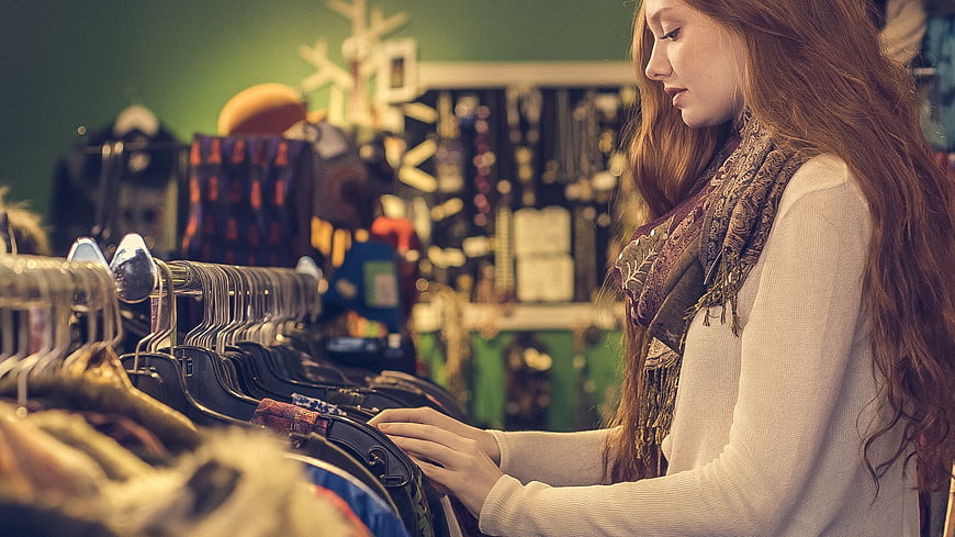 Young woman browsing clothes in a vintage boutique