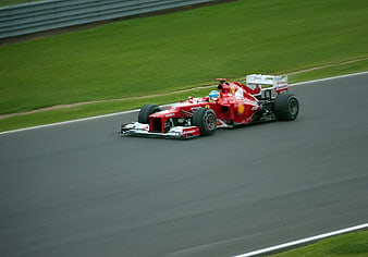 Red Formula 1 Race Car Driving on Track