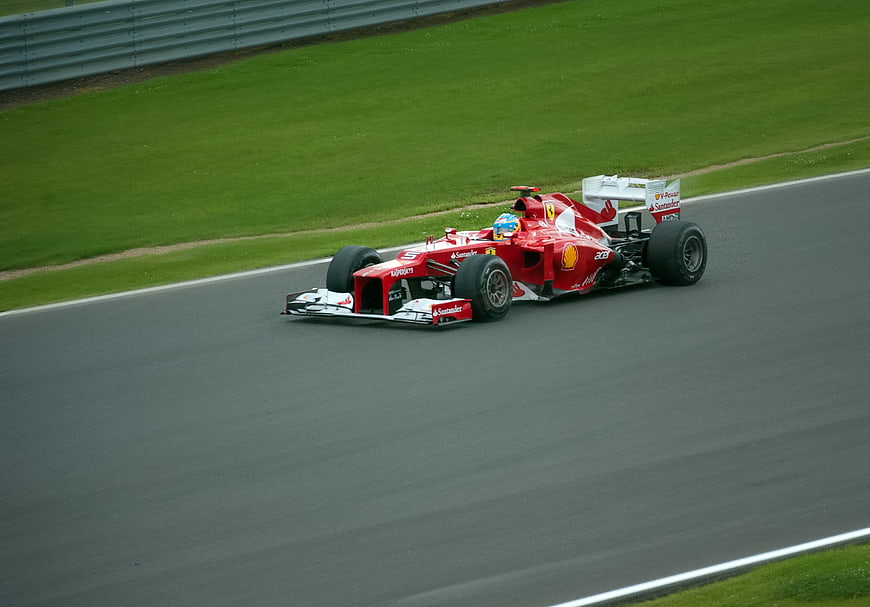 Red Formula 1 Race Car Driving on Track