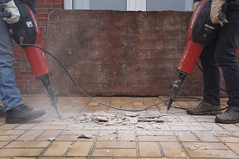 Workers Using Jackhammers To Demolish Concrete Floor Tiles