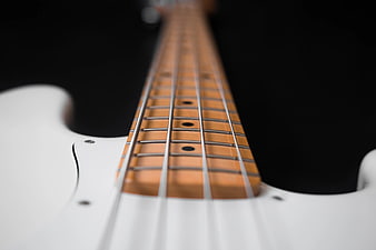 Close-up of White Electric Bass Guitar Neck on Black Background