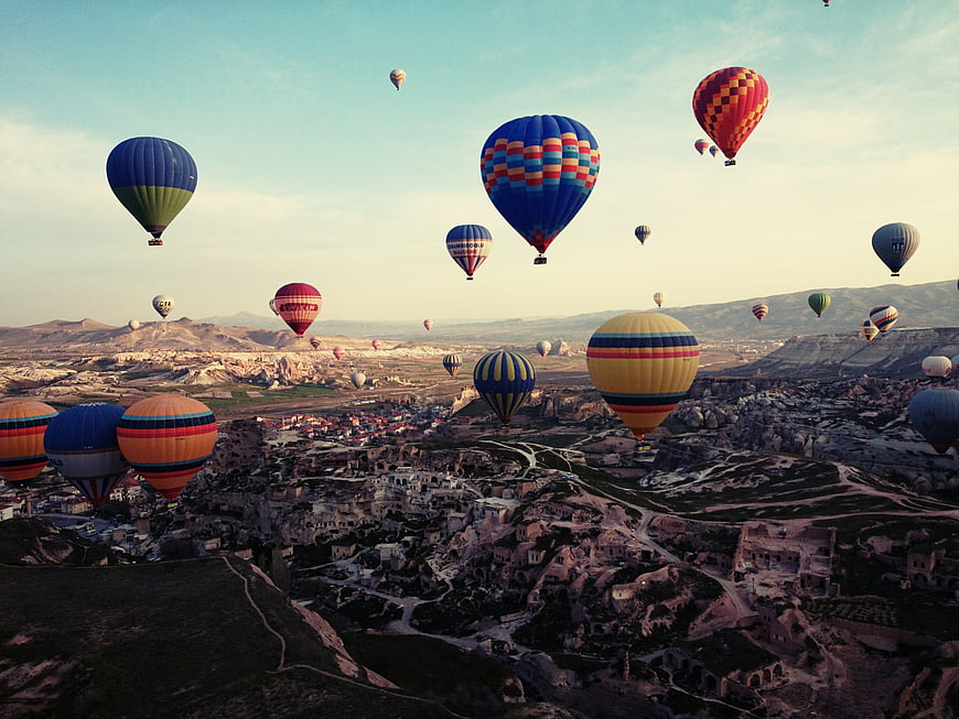Hot Air Balloons Flying Over Cappadocia Landscape at Sunrise