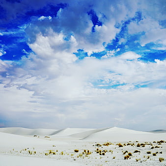 White Sand Dunes Under Dramatic Blue Sky with Clouds