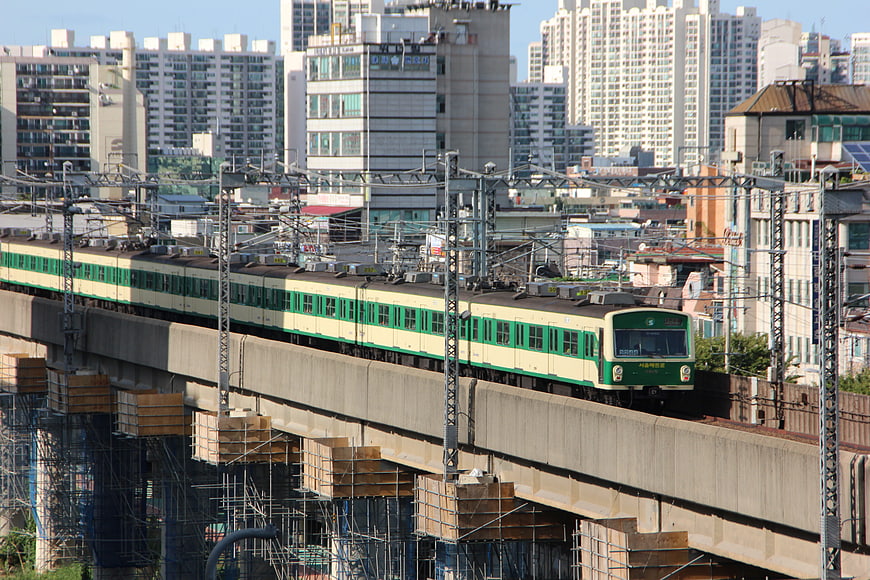 Green and cream subway train on elevated track in Seoul