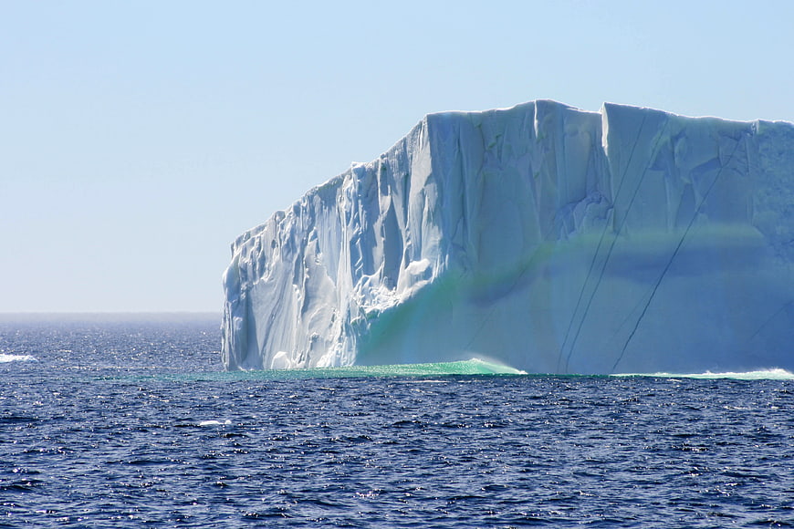 Massive Tabular Iceberg Floating in Deep Blue Ocean
