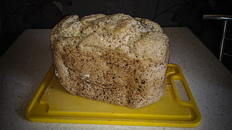 Homemade Whole Grain Bread Loaf on Yellow Cutting Board