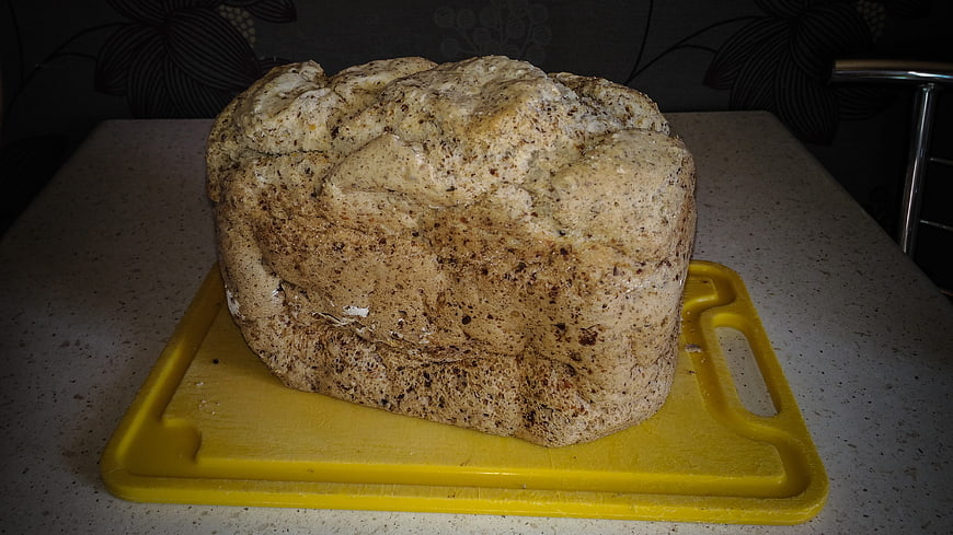 Homemade Whole Grain Bread Loaf on Yellow Cutting Board
