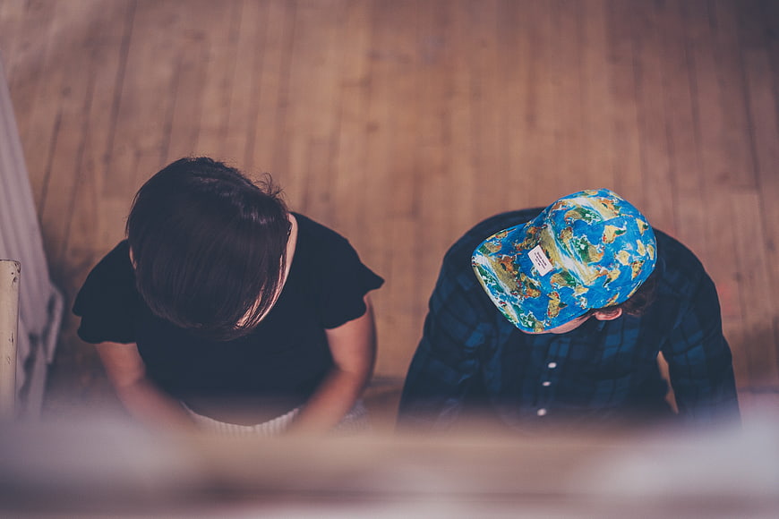 High angle view of couple sitting on wooden floor