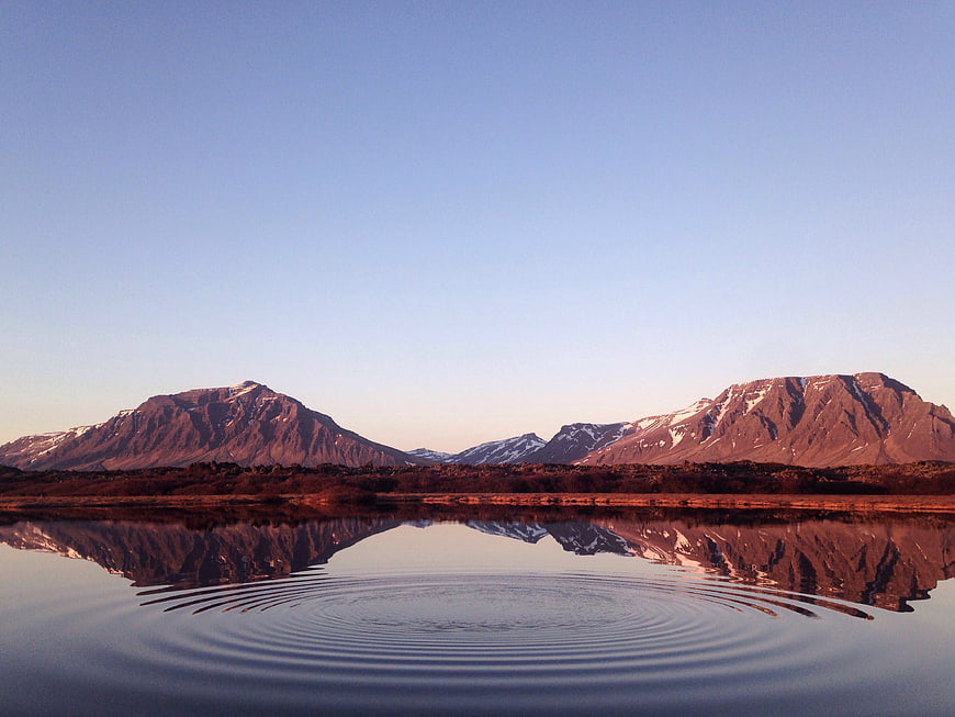 Snowy Mountain Reflection in Calm Lake with Ripples