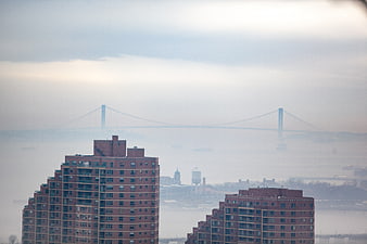 Foggy urban skyline with bridge and brick buildings