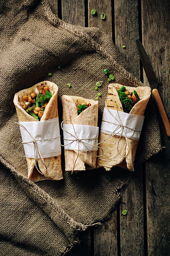 Healthy vegan wraps with chickpeas and broccoli on rustic wood