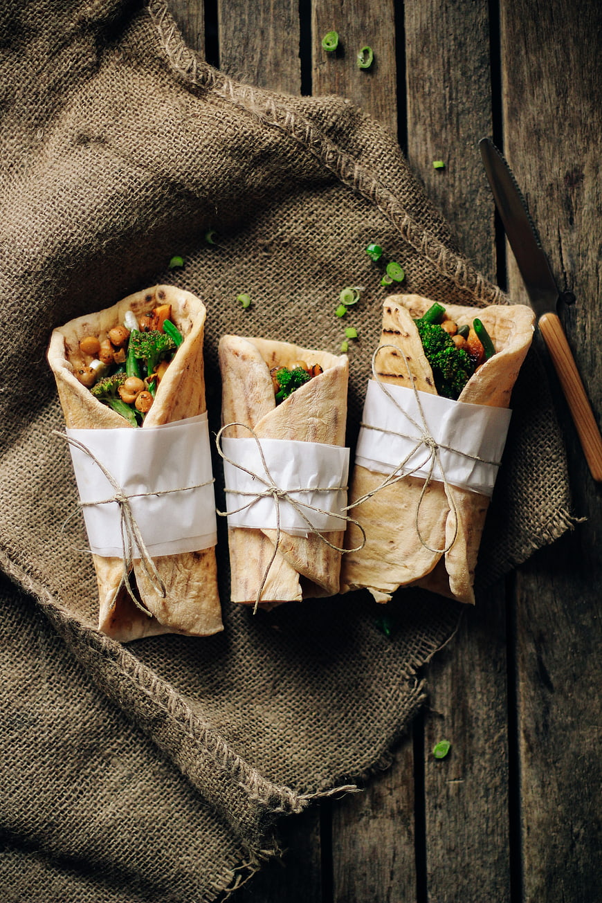 Healthy vegan wraps with chickpeas and broccoli on rustic wood