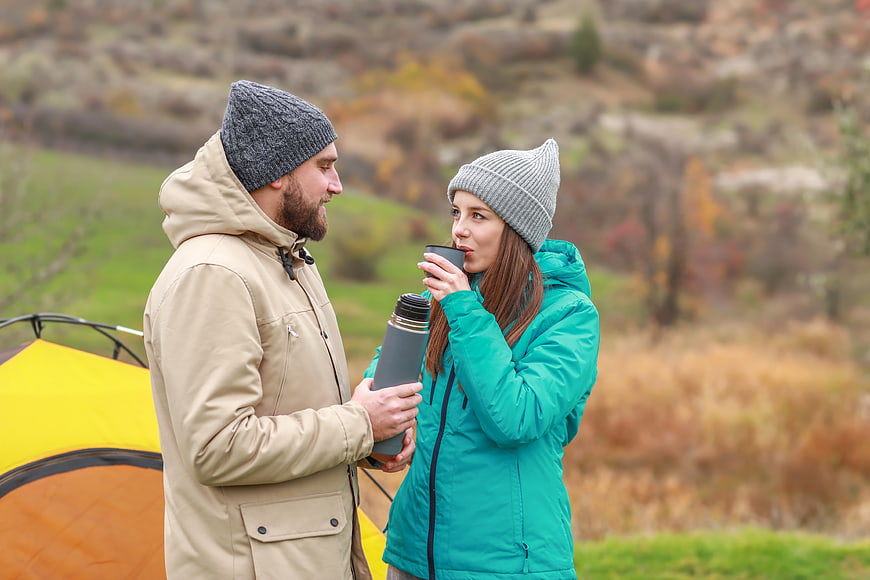 Happy Couple Camping in Autumn with Thermos