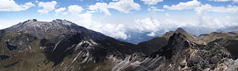 Panoramic mountain landscape with rocky peaks and clouds