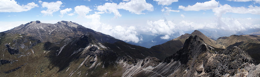 Panoramic mountain landscape with rocky peaks and clouds