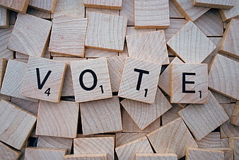 Vote spelled with wooden Scrabble tiles on pile