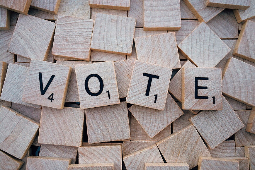 Vote spelled with wooden Scrabble tiles on pile
