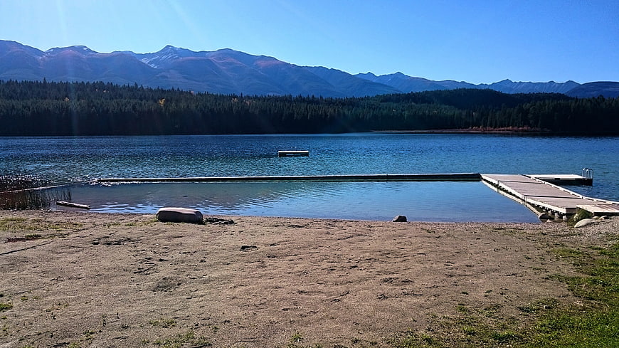 Serene Lake with Wooden Dock and Mountain Backdrop