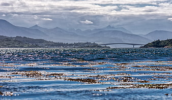 Scenic coastal view with bridge and mountains