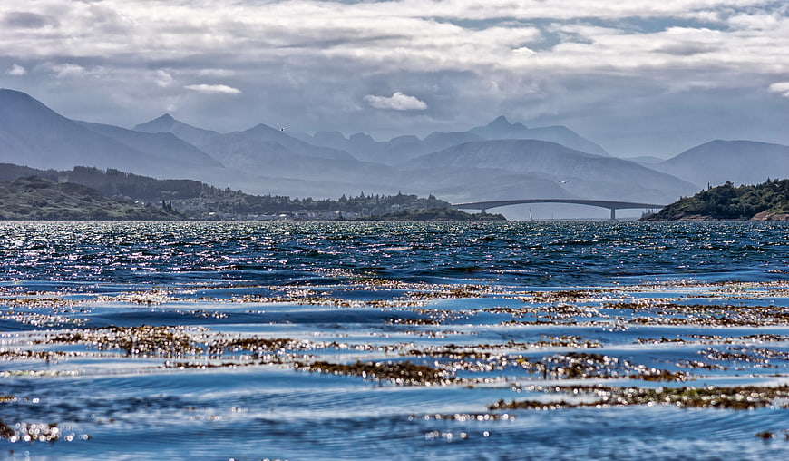 Scenic coastal view with bridge and mountains