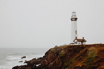 White Lighthouse on Rocky Cliff Overlooking Ocean