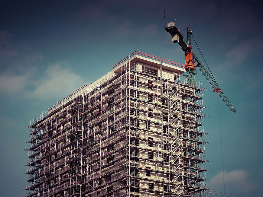 High-rise building under construction with crane and scaffolding