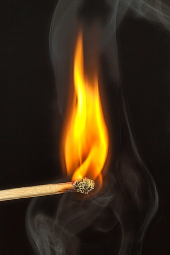 Close-up of burning matchstick with flame and smoke