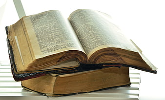 Open antique bible resting on a closed vintage book