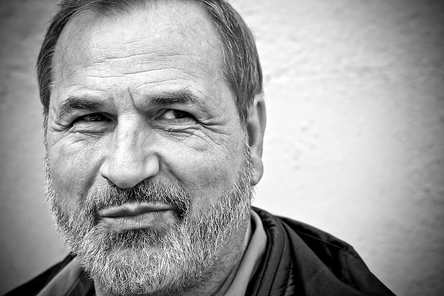 Close-up black and white portrait of a smiling bearded man