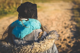 Woman in winter coat walking on dirt path outdoors
