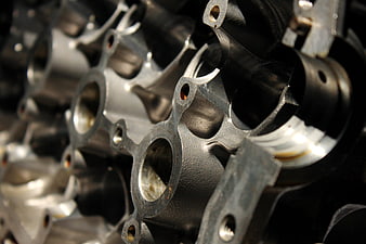 Close-up of metallic engine cylinder block with bokeh background