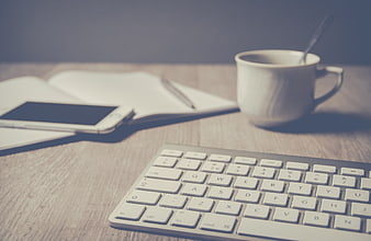 Minimalist Workspace with Keyboard, Coffee, and Notebook