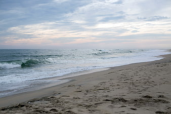 Serene Beach Landscape with Rolling Waves and Cloudy Sky