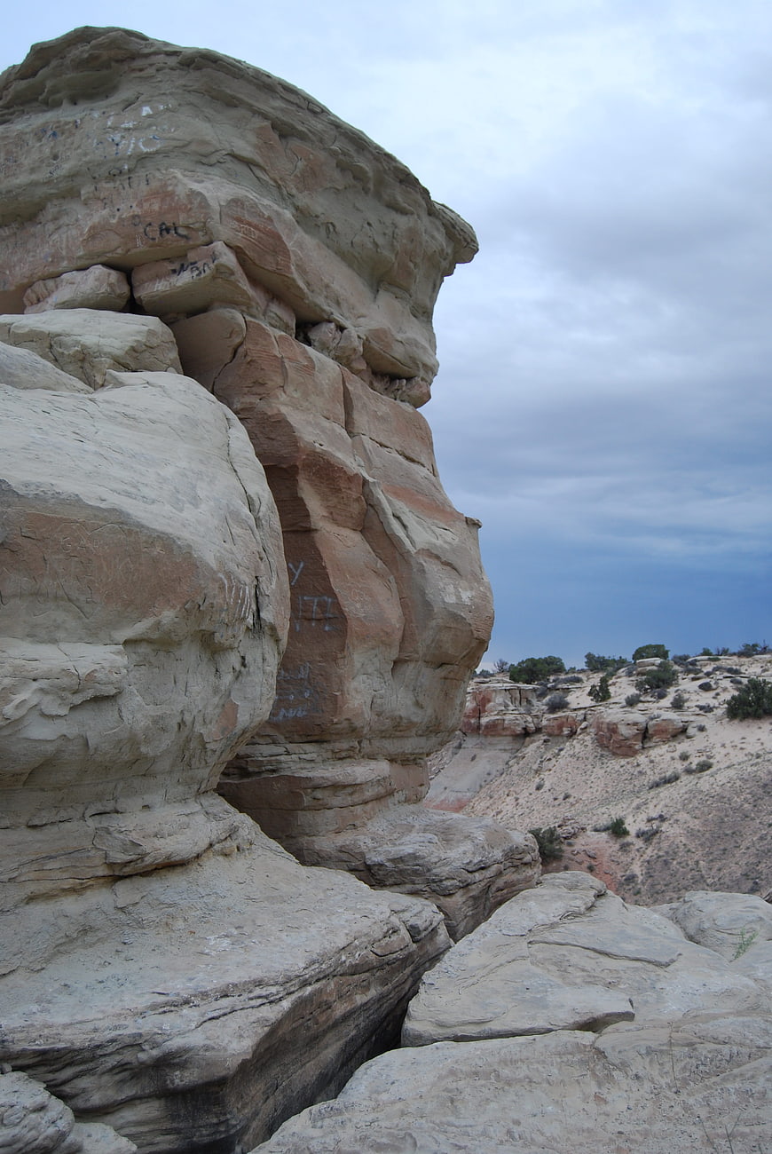 Desert Rock Formation with Graffiti Under Cloudy Sky