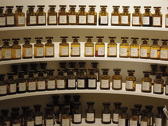 Rows of amber perfume bottles on white shelves