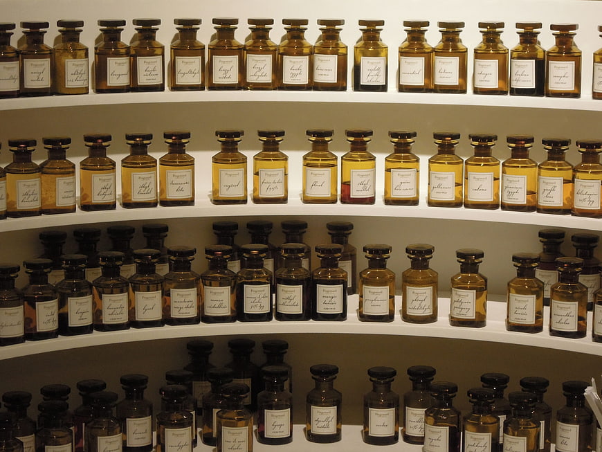 Rows of amber perfume bottles on white shelves