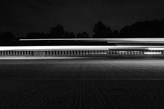 Black and white long exposure light trails on road at night