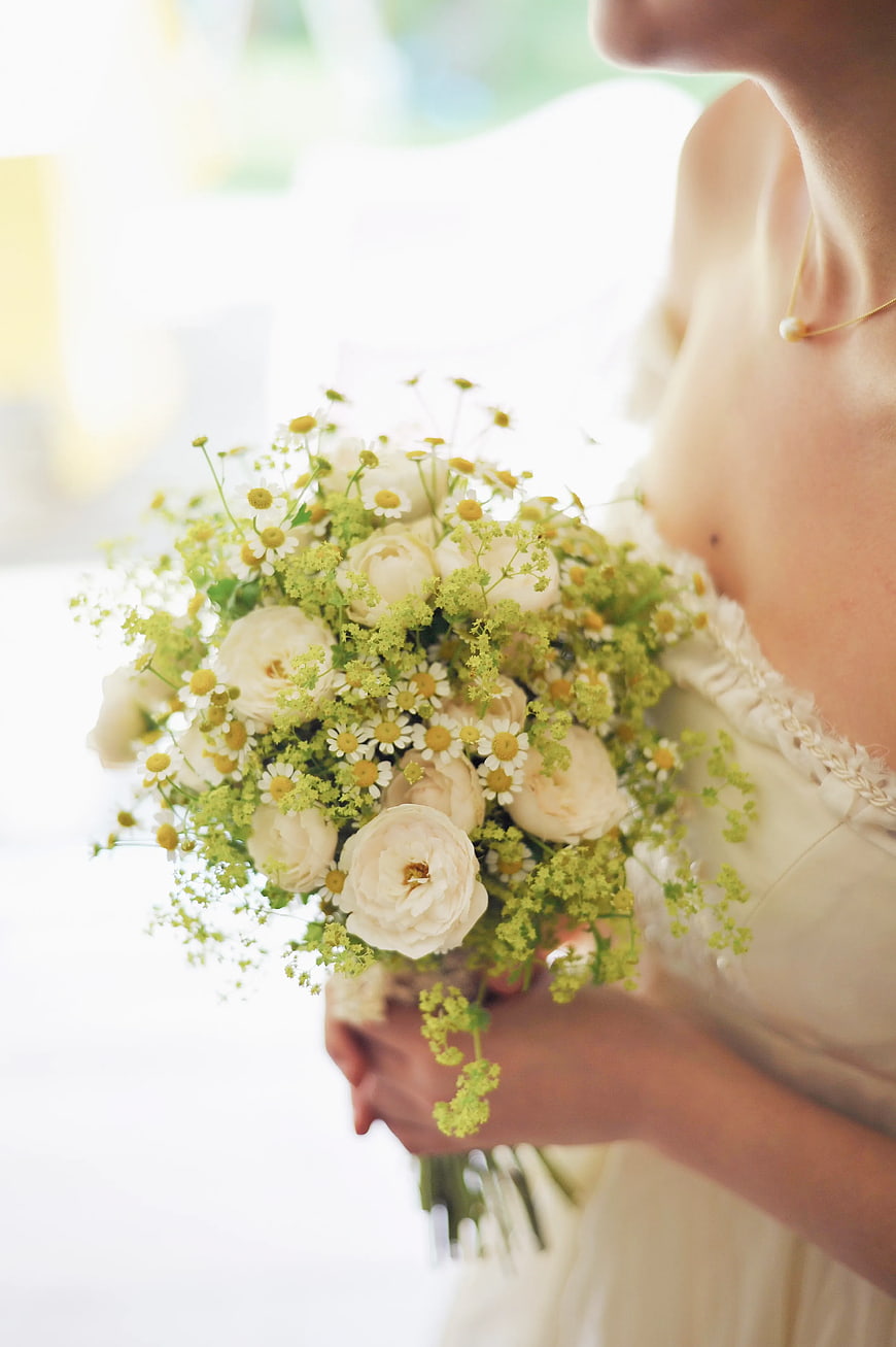 Bride holding white and green floral bouquet close-up
