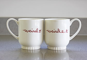 Two white mugs with red text 'weirdo' and 'weirdest'