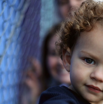 Close-up portrait of a toddler with curly hair looking sideways