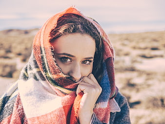 Woman in Plaid Scarf Looking at Camera in Desert