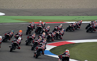 Motorcycle racers leaning into a curve on a race track