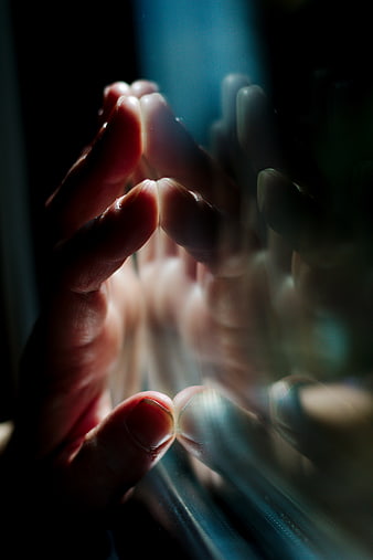 Close-up of hand touching glass with motion blur and light