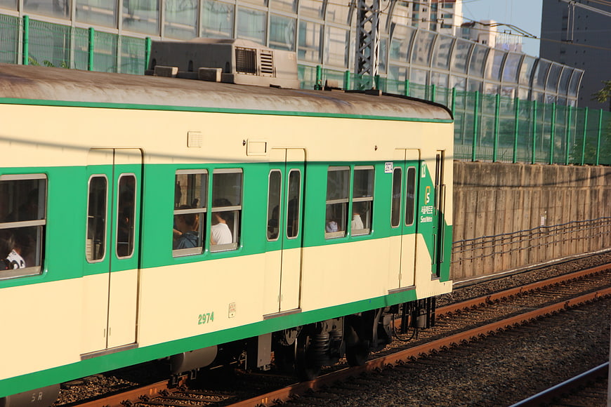 Green and cream commuter train on urban tracks in South Korea
