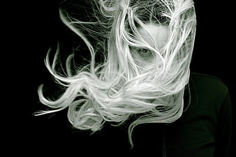 Woman with face covered by flowing white hair