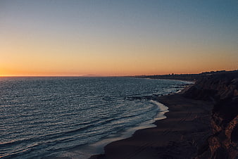 Serene Sunset Over Coastal Beach and Cliffs