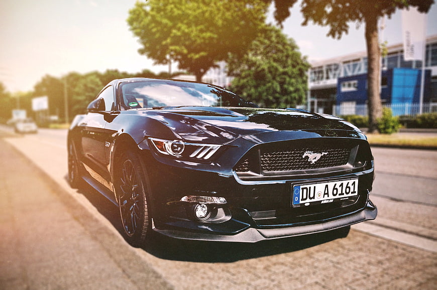 Black Ford Mustang GT parked on a sunny street