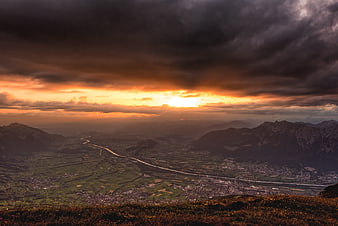 Dramatic sunset over mountain valley with winding river