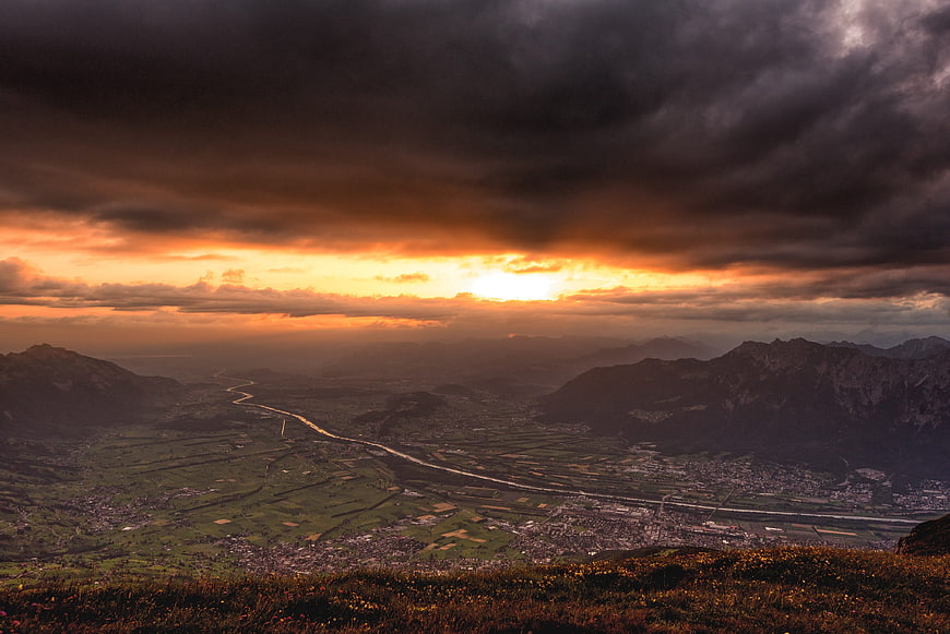 Dramatic sunset over mountain valley with winding river